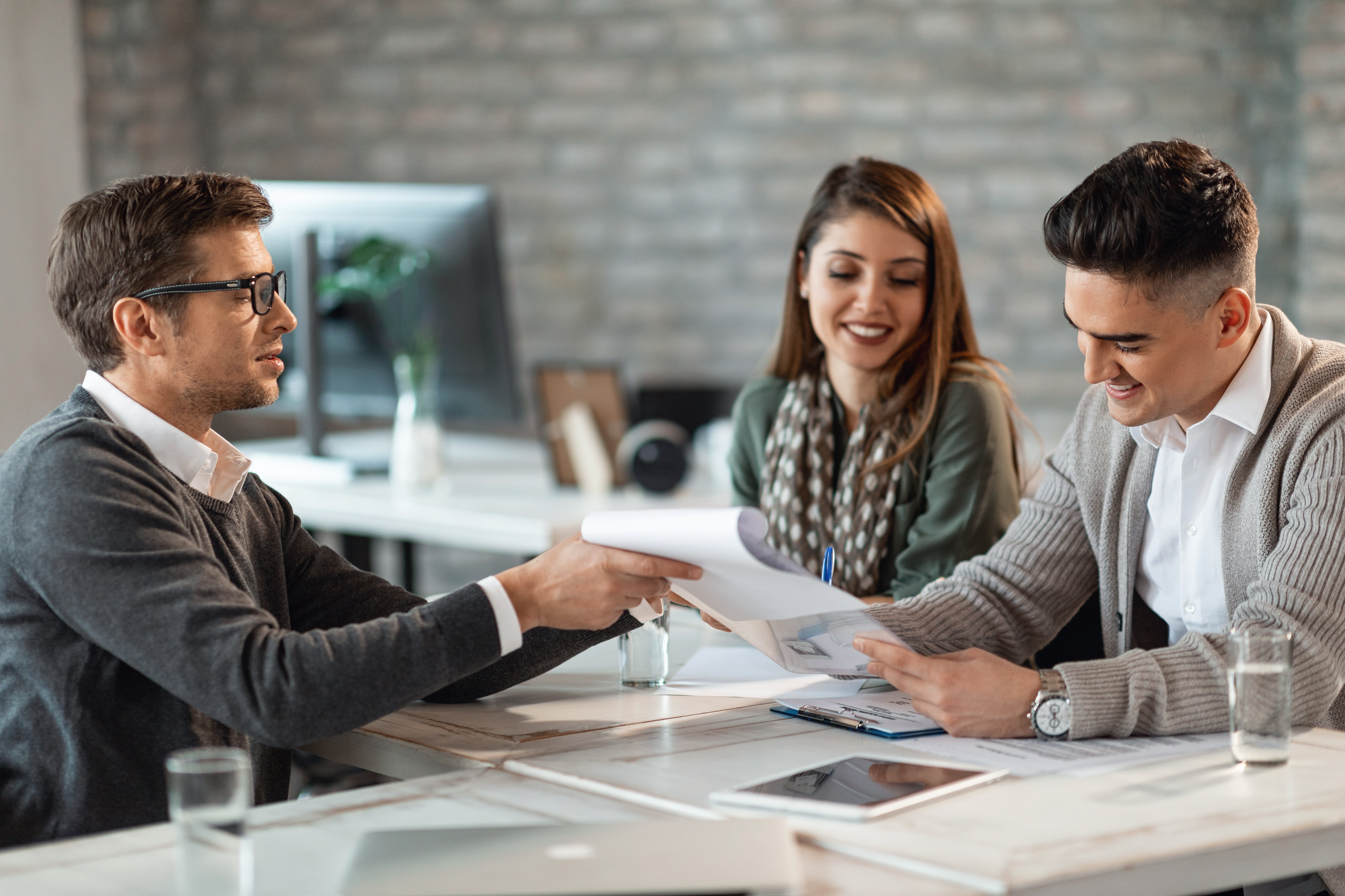 happy-couple-signing-contract-meeting-with-their-real-estate-agent-office (1)